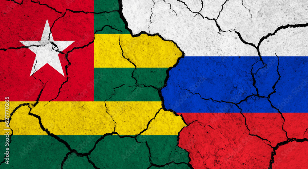 Flags of Togo and Russia on cracked surface - politics, relationship concept
