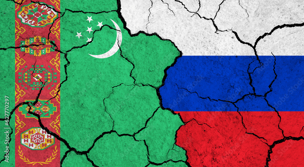 Flags of Turkmenistan and Russia on cracked surface - politics, relationship concept Flags of Turkmenistan and Russia on cracked surface - politics, relationship concept