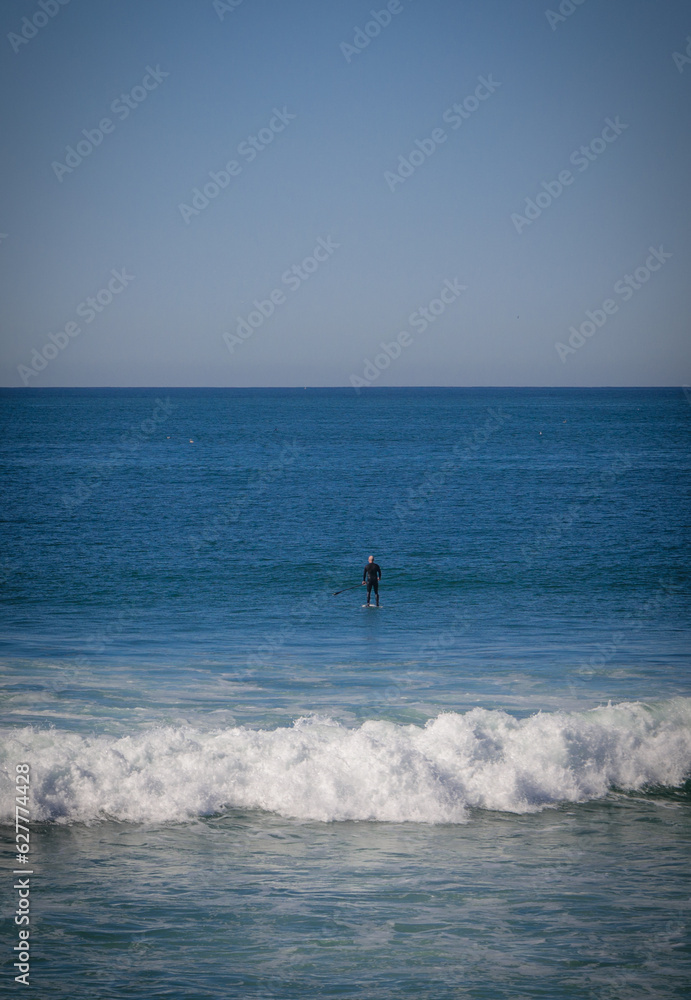 Person Paddleboarding in the Ocean