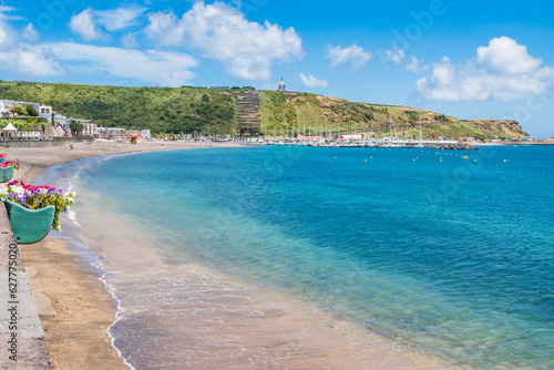 Turquoise water of the bay of Praia da Vitória with marina and hill with the Facho viewpoint in the background in Porto Martins, Terceira - Azores PORTUGAL