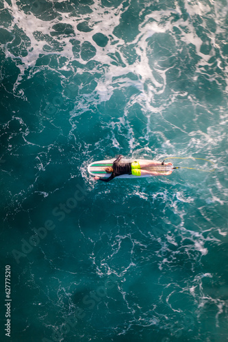 Canvas Print Man surfing in waiao, top down drone shot
