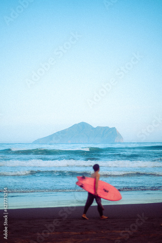 Man carrying a pink surfboard in waiao beach, taiwan
