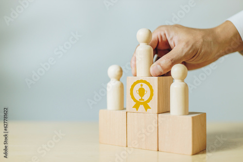 A man holding wood person model standing on award podium. Concept of leadership, success,winner and victory in business