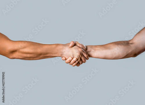 Business handshake and business people concepts. Two men shaking hands isolated on gray background. Close-up image of a firm handshake between two colleagues. Handshakings. Shaking hands two male