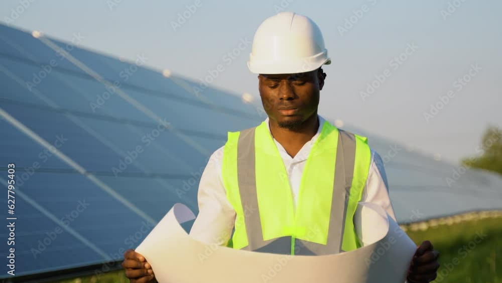 African american engineer worker in hardhat holding solar plan. Green electricity future concept African american engineer worker in hardhat holding solar plan. Green electricity future concept