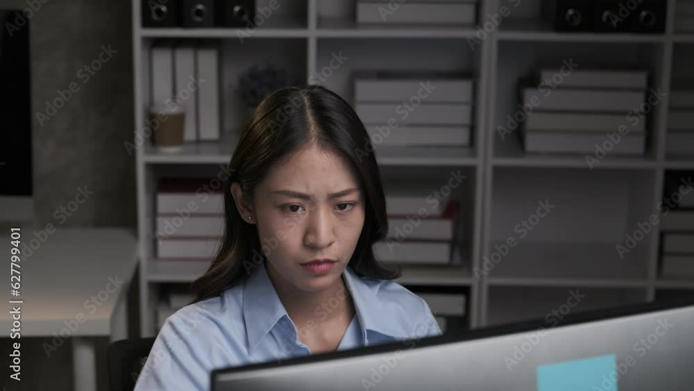Stressful Asian businesswoman having a headache while working overtime at night, feeling tired after a long day at work. Stressful Asian businesswoman having a headache while working overtime at night, feeling tired after a long day at work.
