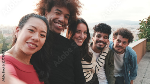 Close-up of young people standing on the balcony taking selfie on mobile phone