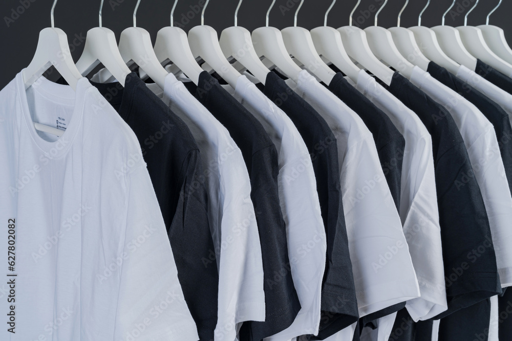 Obraz premium close up collection of black-white and green color t-shirt hanging on wooden clothes hanger