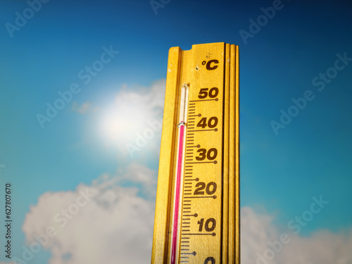 Hot summer day, the thermometer displays a high heatwave temperature of 43 degrees Celsius. A red alarm gives a warning of the extreme weather conditions caused by global climate change on Earth.