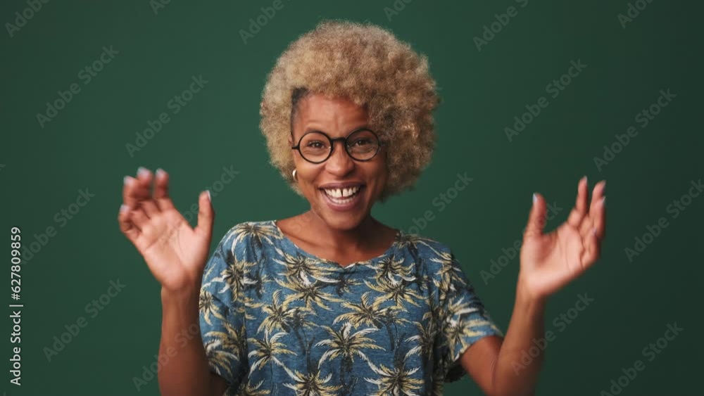Young woman waves palms in hello isolated on blue background, studio shot Young woman waves palms in hello isolated on blue background, studio shot