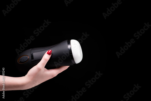 Sex toys for men. Artificial vagina for masturbation in the hands of a girl on a black background. Male massager. Sex Shop Adult Shop