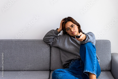 Tableau sur toile black-haired woman in gray sweater watching boring tv
