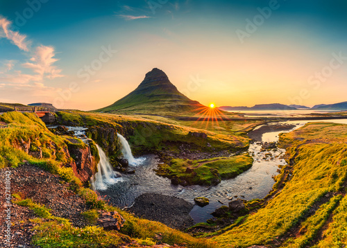 Sunrise over volcanic Kirkjufell mountain with waterfall flowing in summer at Iceland photo