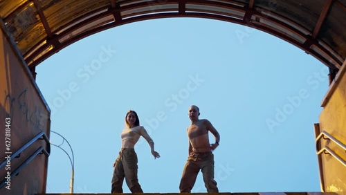 Rhythmic movements of a pair of dancers on the evening street in time with the music. City lights, urban landscape, modern dance. High quality 4k footage