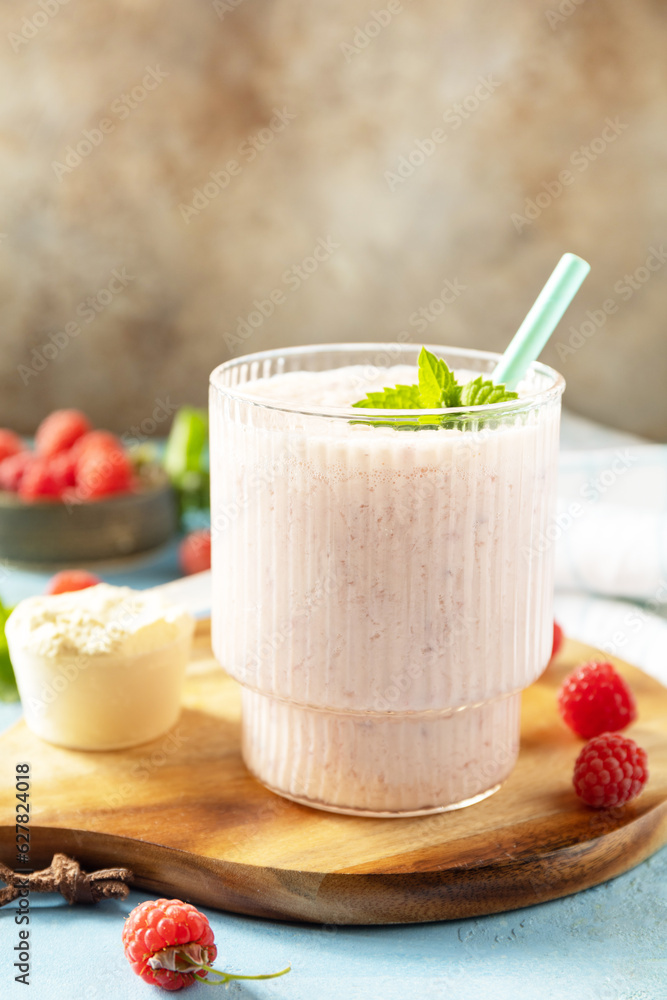 Fresh milk, raspberries drink on wooden board on a stone background, protein shake with fresh berries. Copy space. Fresh milk, raspberries drink on wooden board on a stone background, protein shake with fresh berries. Copy space.