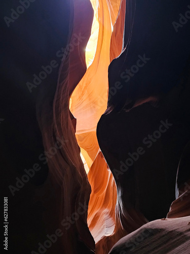photo of antelope canyon on the navajo reservation. warm light filtering through the rocks, creating beautiful orange, red and yellow colors. Signs of rock erosion caused by water and wind