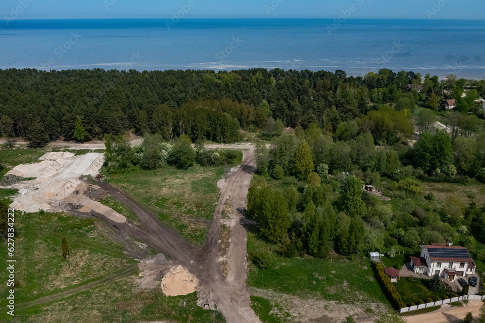 Top drone view of construction site near forest. White sand. Nature of Jurmala. Baltic sea. Modern house.