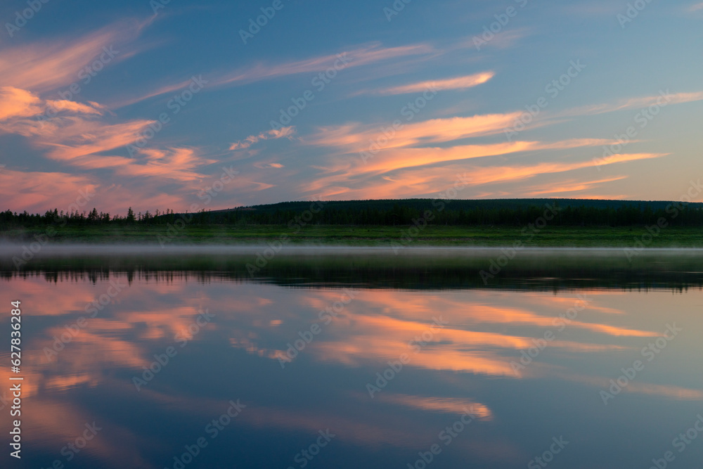 Sunset tranquility, pink clouds reflecting in the still river 