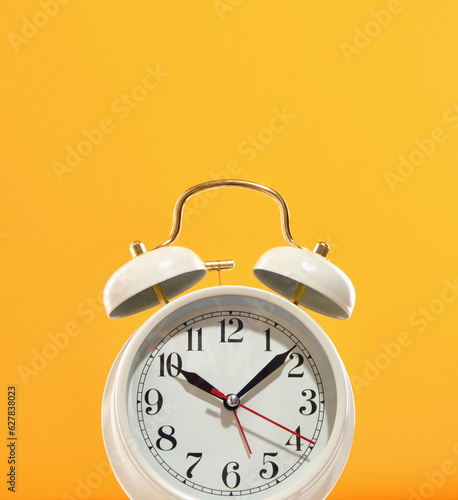 Morning time. A vintage old white alarm clock on a colored background. Wakes up for work.