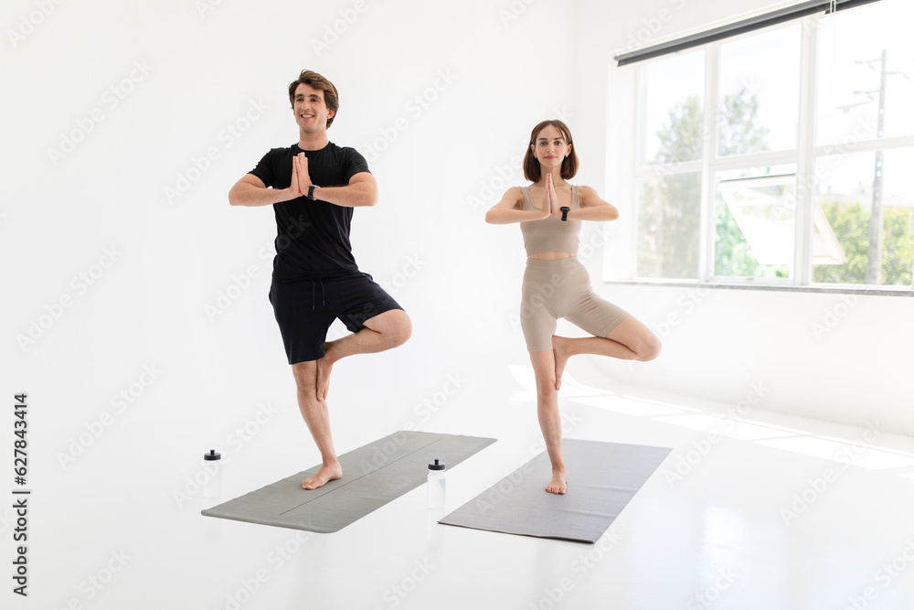 Glad calm young caucasian lady and guy in sportswear enjoy workout together, health care, meditate Glad calm young caucasian lady and guy in sportswear enjoy workout together, health care, meditate