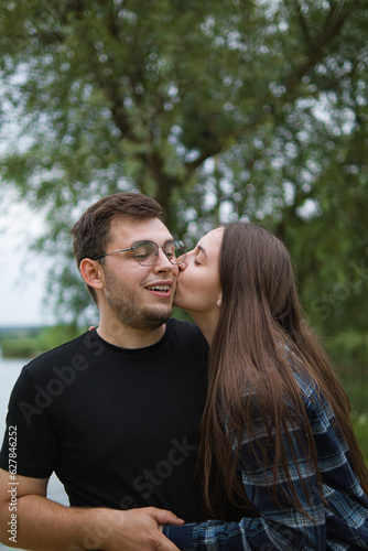 Romantic couple.Love relationship.Boyfriend and girl.Husband and wife.Happy moments together.Date in nature.Spring portrait.Emotions of joy and happiness.Happy news.Couple in nature.girl kissing guy.