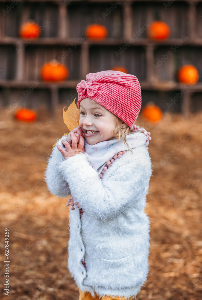 smiling happy little child girl in coat holding autumn leaves, having fun in fall forest smiling happy little child girl in coat holding autumn leaves, having fun in fall forest