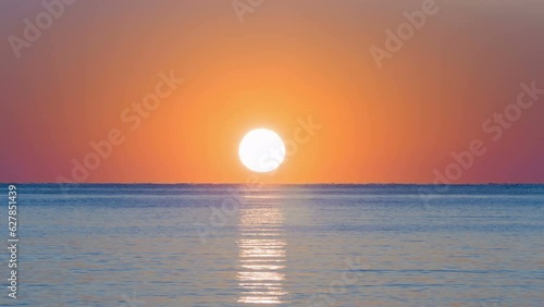The rising sun over the calm and endless ocean