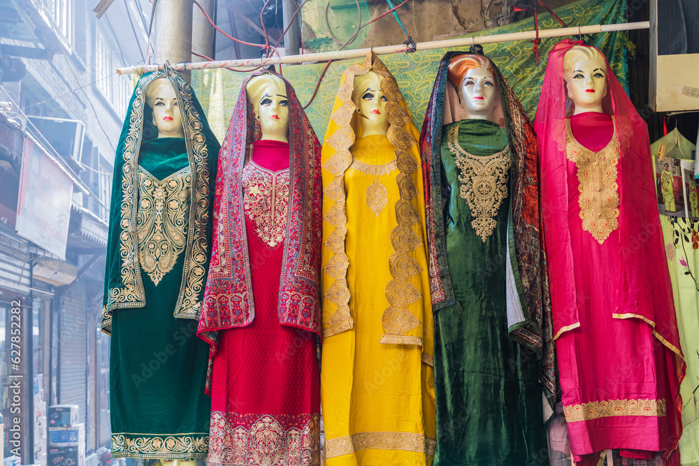 Traditional women's clothes for sale at a market in Srinagar.