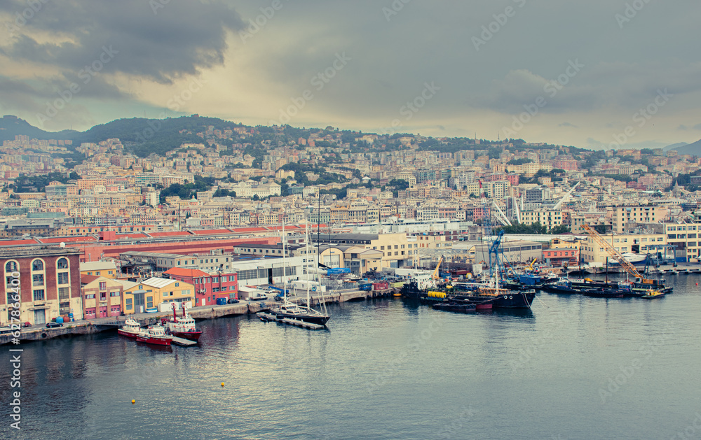 A port in Genoa with buildings in the background, cloudy weather.
