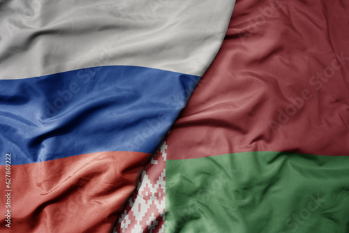 big waving realistic national colorful flag of russia and national flag of belarus .