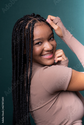 Portrait of beautiful young woman with hands on her head. Braided hair.