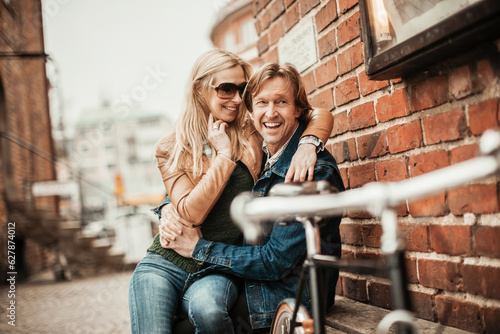 Mature couple sitting on a bench after riding bikes in the city