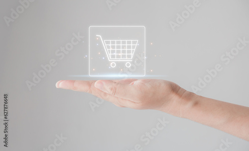 Online shopping concept. customer hand holding the shopping cart icon on the virtual screen for global concepts.