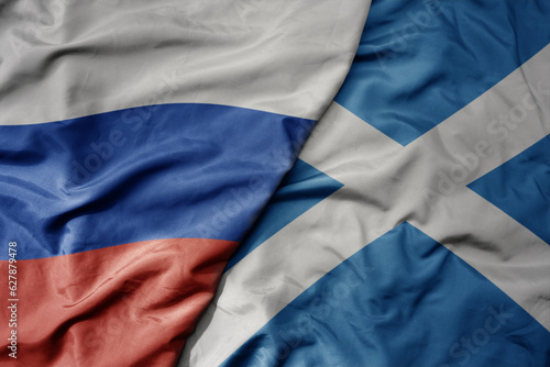 big waving realistic national colorful flag of russia and national flag of scotland .