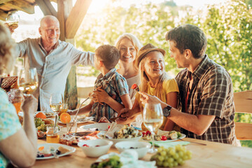 Multigenerational family enjoying a family lunch on a patio at a vineyard