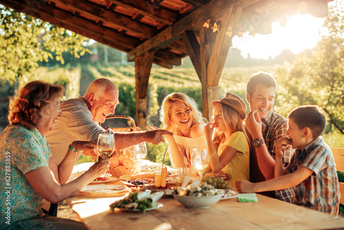 Fototapet Multigenerational family having a family lunch outdoors on a patio