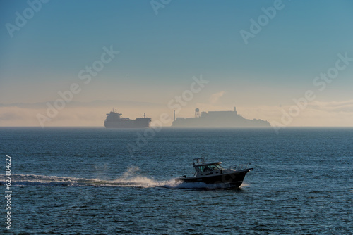 Fishing boat passes in front of oil tanker and Alcatraz on San Francisco Bay