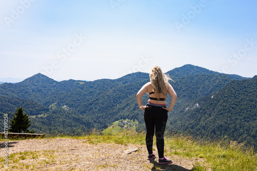 Woman standing on hill and looking at mountains