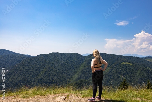 Woman standing on hill and looking at mountains