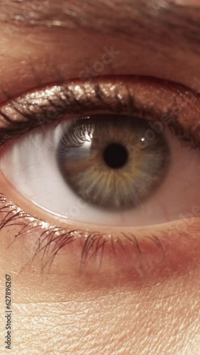 Vertical video. Vision correction. Laser surgery. Sight ophthalmology. Macro of female woman dilated pupil in darkness getting smaller on bright light.