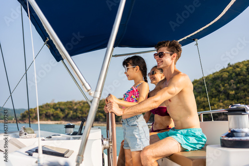 Caucasian happy family driving yacht outdoors on the sea during summer. 
