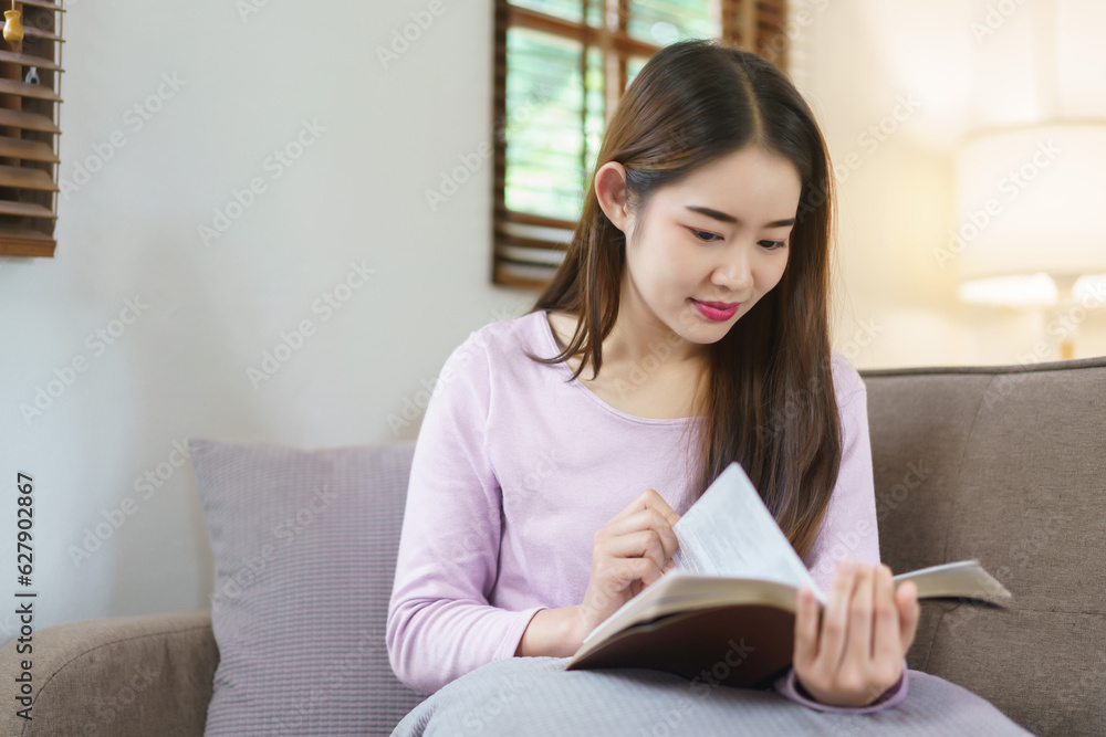 Women reading a book while sitting on big sofa to relaxation with happiness in lifestyle at home Women reading a book while sitting on big sofa to relaxation with happiness in lifestyle at home