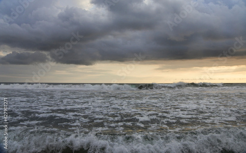 A Man ready to surf at Seminyak beach.