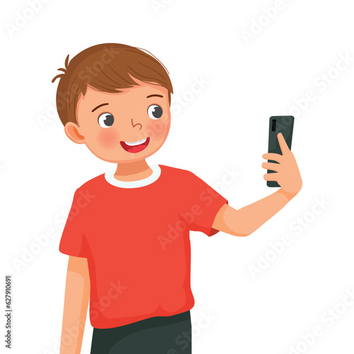 Cute little boy taking selfie with smartphone with happy expression