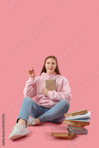 Teenage girl with books poi...