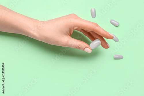 Woman with press-on nails on green background