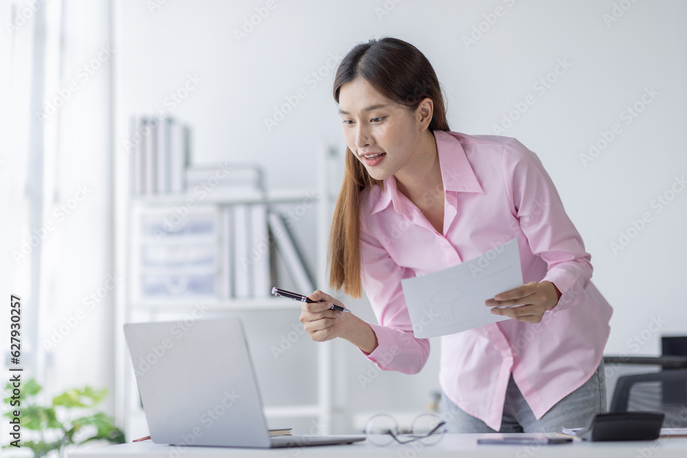 Asian Businesswoman Using laptop computer and working at office with calculator document on desk, doing planning analyzing the financial report, business plan investment, finance analysis concept.
Asian Businesswoman Using laptop computer and working at office with calculator document on desk, doing planning analyzing the financial report, business plan investment, finance analysis concept.