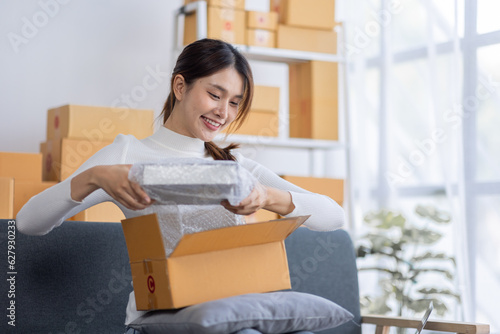Portrait of Starting small businesses owners female entrepreneurs working on receipt box and check online orders to prepare to pack the boxes, sell to customers, sme business ideas online.
