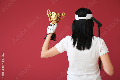 Female golfer with gold cup...