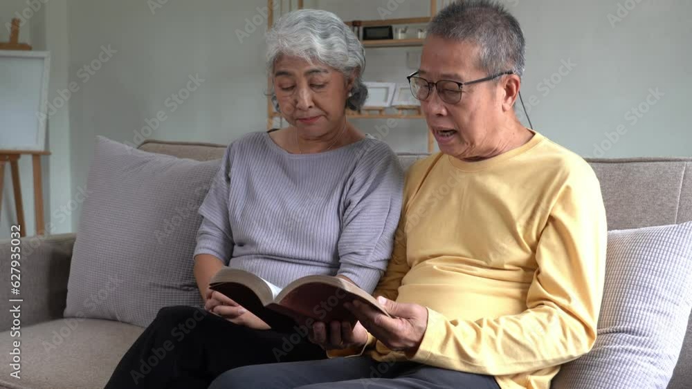 An Elderly Asian Couple reading bible and pray with hope or faith at home, Christian concept background. An Elderly Asian Couple reading bible and pray with hope or faith at home, Christian concept background.